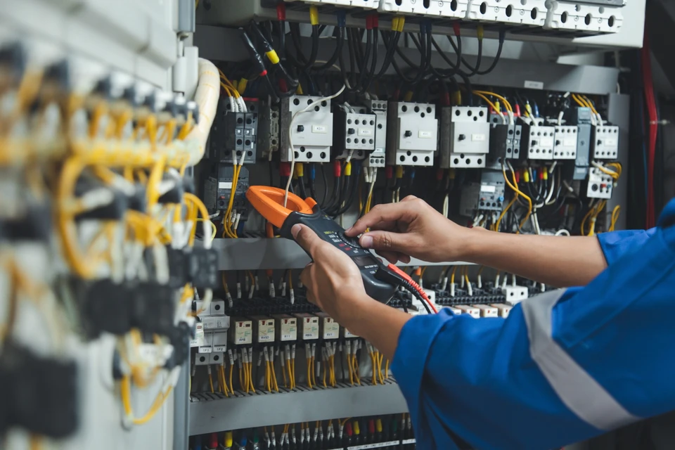 Électricien professionnel installant un interrupteur mural dans un intérieur résidentiel